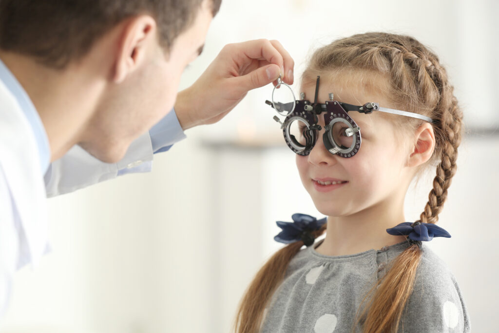 Photo d'un enfant portant des lunettes d'essai lors d'une consultation en ophtalmologie