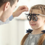 Photo d'un enfant portant des lunettes d'essai lors d'une consultation en ophtalmologie